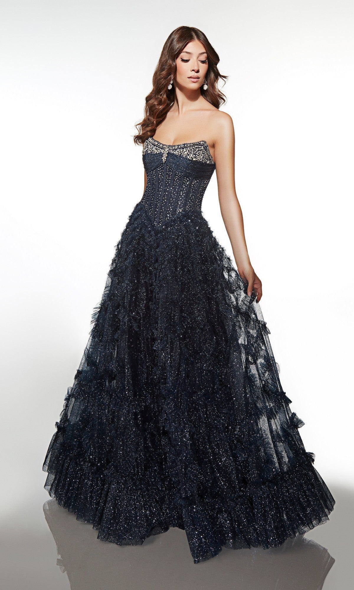 A woman wearing the Alyce 62096 long formal dress in Black Plum, featuring an embellished corset bodice and ruffle tiered tulle skirt, poses against a plain white background.